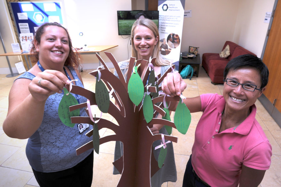 The Oxford Health Charity's Healthfest 2019 at The Warneford Hospital, Oxford. The Oxford Healthcare Improvement team with their suggestion tree to which visitors were invited to place suggestions for improvements written on leaves.