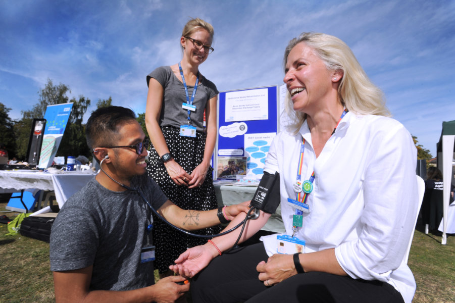 The Oxford Health Charity's Healthfest 2019 at The Warneford Hospital, Oxford. Advanced nurse practitioner JC takes highly specialist occupational therapist Sarah King's blood pressure, watched by clinical physiotherapist Emma Garrett, centre.