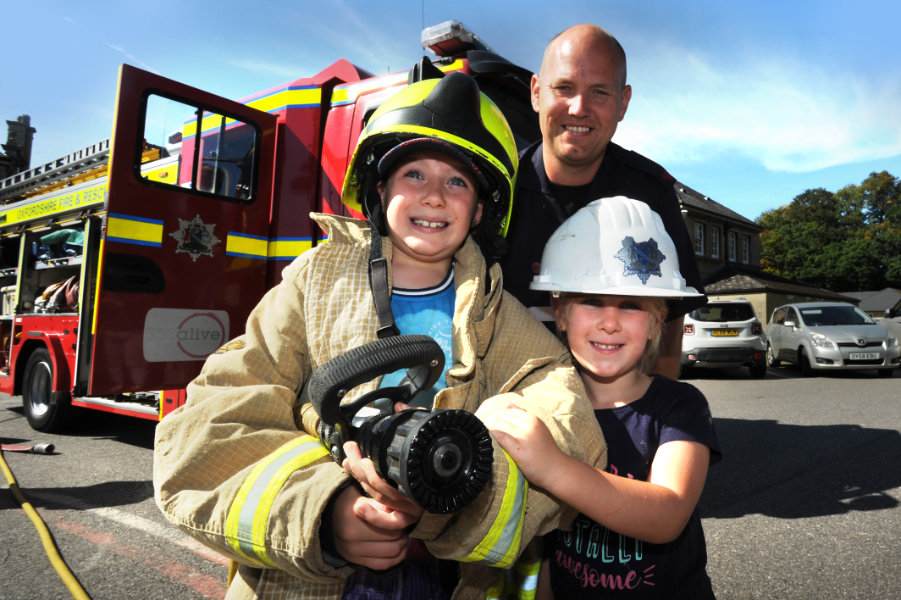 The Oxford Health Charity's Healthfest 2019 at The Warneford Hospital, Oxford. Oxfordshire County Council's Fire and Rescue Service fire engine proved a popular attraction. Fire Fighter Tim Rial, from the Slade Fire Station's Green Watch, with a pair of keen potential recruits!