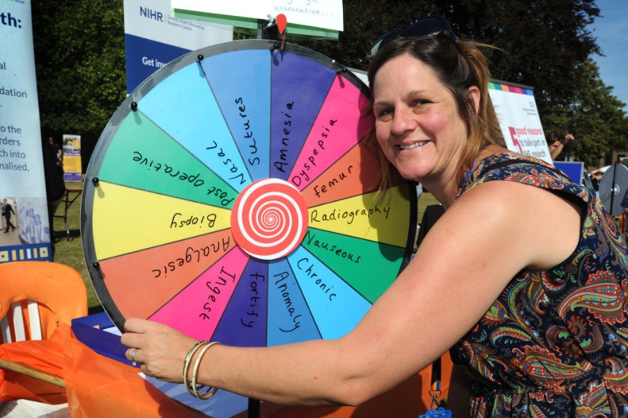 The Oxford Health Charity's Healthfest 2019 at The Warneford Hospital, Oxford. Patient and public involvement manager (research), Claire Murray, with her "Wheel of Jargon" for people to spin to land on a jargon word which they could suggest a layman's term for.